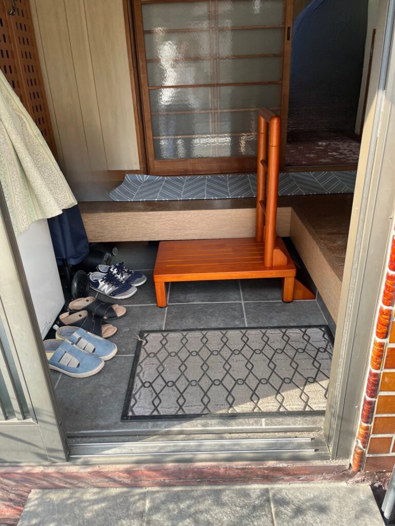 玄関の外から見た样子。三和土に木製の踏み台が置かれ、廊下への段差が小さくなっている