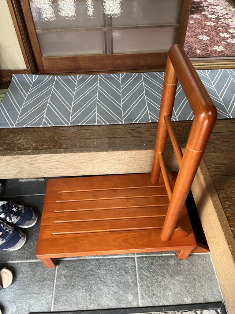 木製の手すり付き玄関踏み台。天板には滑り止めの溝が入っている