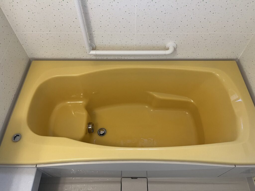 掃除後の黄色い浴槽。つやがあり、水あかがない