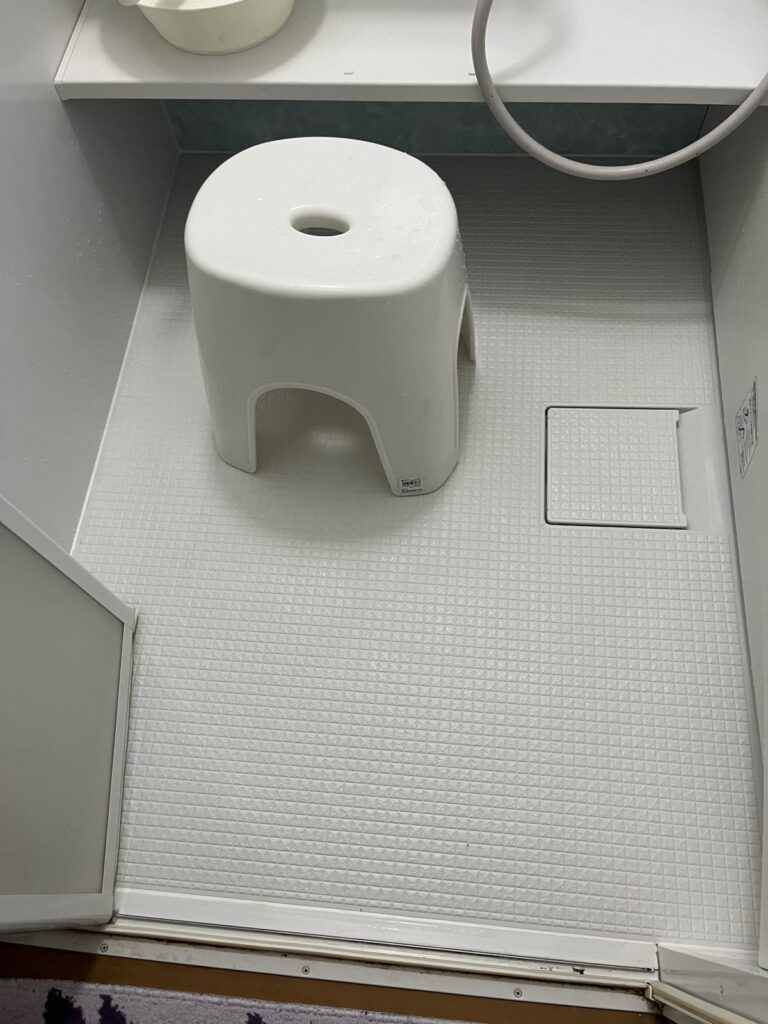 浴室の床と風呂椅子。床の目地まで白くなっている